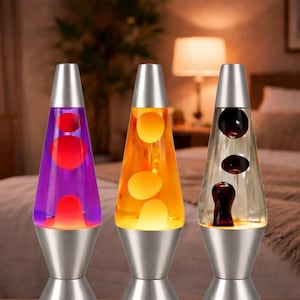 May include: Three lava lamps with silver bases and tops. The lamps feature different colored liquids and lava: purple with red lava, orange with yellow lava, and clear with dark red lava. The lamps are cone-shaped.