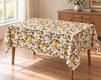 Könnte beinhalten: Eine rechteckige Tischdecke mit cremefarbenem Hintergrund und einem sich wiederholenden Muster aus gelben Birnen, grünen Blättern sowie kleinen rosa und weißen Blüten. Der Stoff bedeckt die Oberseite und die Seiten eines Holztisches.