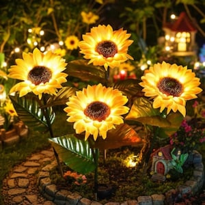 Könnte beinhalten: Solarbetriebene Sonnenblumen-Gartenleuchten. Die künstlichen Sonnenblumen haben leuchtend gelbe Blütenblätter und dunkelbraune Zentren. Die Blätter sind grün. Die Lichter sind in einem Garten mit einem Steinweg und einem kleinen dekorativen Haus im Hintergrund angeordnet.