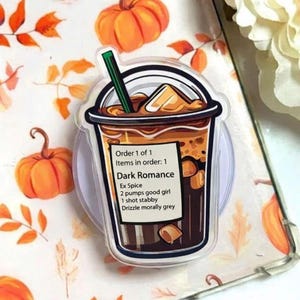 May include: A clear acrylic pop socket featuring a coffee drink design with a green straw. The drink is labeled "Dark Romance" with a list of ingredients. The background includes orange pumpkins and fall leaves.