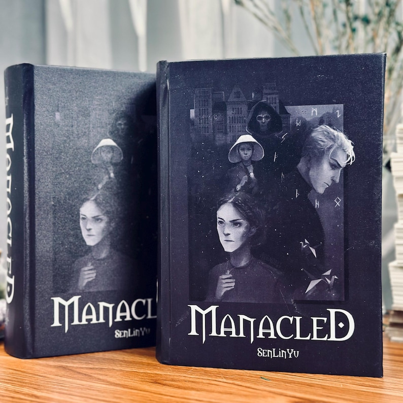 May include: Two hardcover books with the title "Manacled" in white lettering. The covers feature a dark, gothic illustration with figures and architectural elements. The author's name, SenLinYu, is also visible.