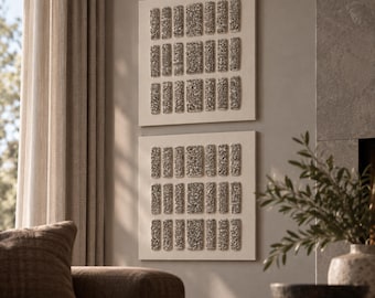 May include: Two square wall art pieces featuring a grid of raised, rectangular textured elements in a metallic silver-grey finish set against a flat, off-white background. Each piece displays three horizontal rows of these textured blocks.