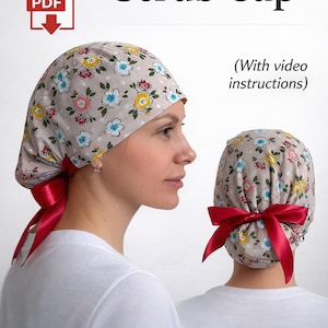 Puede incluir: Una taza de cerámica blanca con un asa negra y el texto "But First, Coffee" en negrita negra. La taza se encuentra sobre un fondo borroso, sugiriendo un ambiente acogedor.