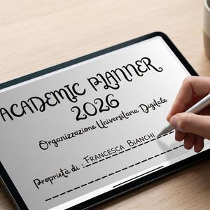 Può includere: Un'agenda accademica digitale per il 2026 visualizzata su un tablet. Lo schermo mostra il titolo "Academic Planner 2026" con testo aggiuntivo. Una mano usa una penna per scrivere sullo schermo. Sono visibili anche una piccola pianta grassa e una tazza di caffè.