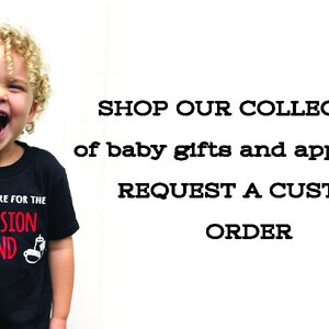 Puede incluir: Un ni&ntilde;o peque&ntilde;o con una camiseta negra con el texto "I'm just here for the concession stand" en blanco y rojo. El ni&ntilde;o sonr&iacute;e y mira a la c&aacute;mara. El texto "SHOP OUR COLLECTION of baby gifts and apparel or REQUEST A CUSTOM ORDER" est&aacute; en negro sobre fondo blanco.
