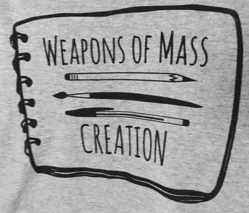 Puede incluir: Una ilustraci&oacute;n en blanco y negro de un cuaderno con el texto "Weapons of Mass Creation" en la portada. El cuaderno tiene una encuadernaci&oacute;n en espiral y tres herramientas de dibujo est&aacute;n ilustradas en la portada.