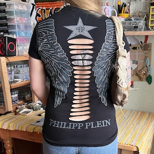 Camiseta Philipp Plein con calavera, alas y espalda descubierta con pedrería.