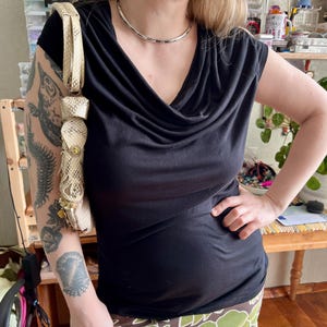 May include: A set of three ceramic mugs with a speckled, matte finish. The mugs are in shades of cream, light gray, and dark gray. Each mug has a simple, minimalist design and a rounded handle.