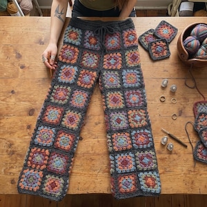 May include: Crochet pants constructed from a series of multicolored granny squares framed in dark gray yarn. The pants feature a drawstring waistband and a wide-leg silhouette. The design incorporates various shades of blue, orange, and purple.