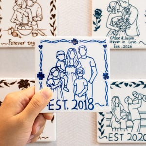 May include: Five square white ceramic tiles featuring blue or brown line art illustrations of families and couples. Each tile includes decorative borders and text such as Forever together, Chloe & Jason, and EST. 2018, 2020, or 2026.