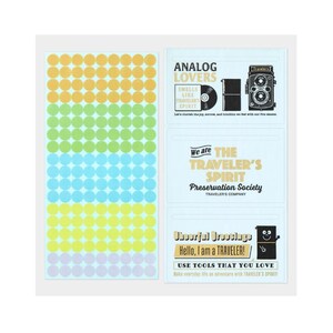 May include: A sticker sheet featuring a range of colours and text. The stickers include circular dots in yellow, orange, green, blue, and purple. Text includes "ANALOG LOVERS" and "TRAVELER'S SPIRIT".