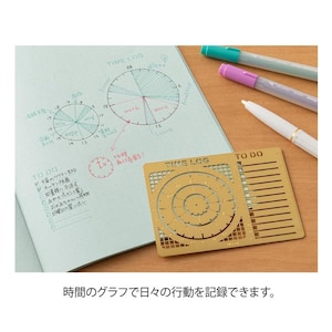 May include: A notebook with handwritten time log and to-do lists, along with a gold-colored stencil for creating circular charts. Colored pens in green, purple, and white are also present. The text in the image says "TIME LOG" and "TO DO".