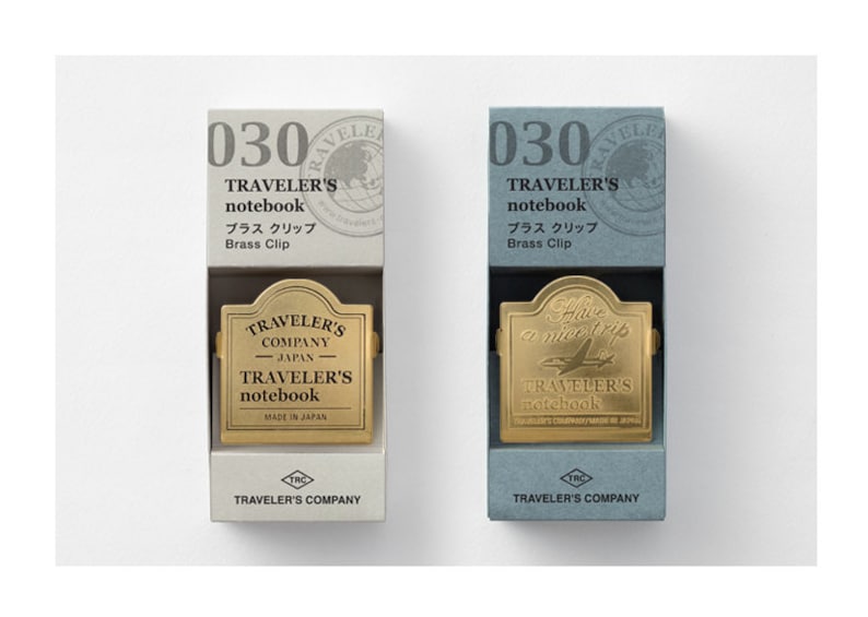 Op de afbeelding: Twee dozen met messingclips voor Traveler's notitieboekjes. De dozen zijn wit en blauw met de tekst "030 Traveler's notebook Brass Clip" op de voorkant. De messingclips hebben de tekst "Traveler's Company Japan Traveler's notebook" erop.