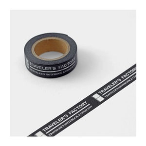May include: A roll of black washi tape with white text that reads "TRAVELER'S FACTORY TRAVELER'S NOTEBOOK & COMPANY".