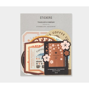 May include: A set of stickers featuring a coffee theme with a brown, black, and white color scheme. The stickers include a coffee cup, a coffee bean, and a cherry blossom design. The text on the stickers reads "Starbucks Reserve Roastery Tokyo" and "Traveler's Company".