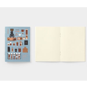 Peut inclure: Un carnet avec une couverture bleu clair ornée d'illustrations sur le thème du café. Le carnet ouvert révèle des pages vierges de couleur crème. La couverture comprend des machines à café, des tasses et un tablier.