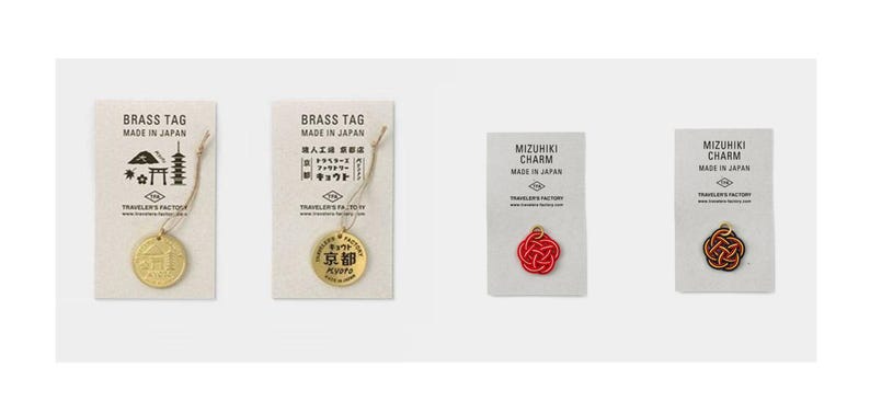 May include: Four brass tags and charms with Japanese characters and designs. The tags are labeled "Brass Tag" and "Made in Japan". The charms are labeled "Mizuhiki Charm" and "Made in Japan".