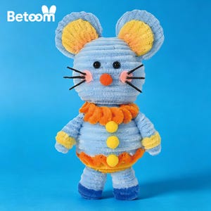 May include: A plush toy mouse with blue corduroy body, yellow and orange accents, and black whiskers. The mouse has a round orange nose, black eyes, and is wearing an orange collar with yellow pom-poms. The toy has the word "Betoom" in white letters.