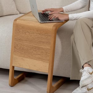 Puede incluir: Una taza de cerámica blanca con un asa negra y el texto "But First, Coffee" en negro, con una fuente de estilo manuscrito. La taza está sobre una superficie blanca.