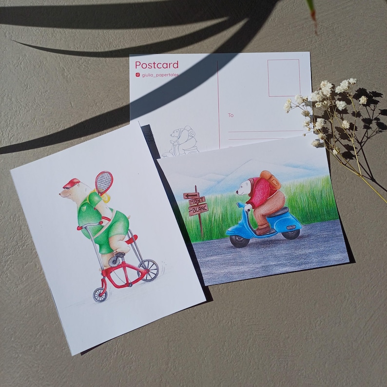 Może przedstawiać: Trzy poczt&oacute;wki z ilustracjami niedźwiedzi. Jedna przedstawia niedźwiedzia na tr&oacute;jkołowym rowerze z rakietą tenisową, druga niedźwiedzia na skuterze, a trzecia to poczt&oacute;wka ze szkicem niedźwiedzia i tekstem "Postcard".