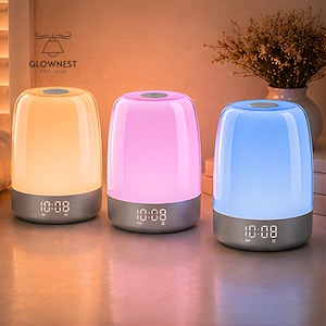 Pode incluir: Três candeeiros de cabeceira nas cores âmbar, rosa e azul, cada um com um design arredondado. Os candeeiros têm uma base cinzenta e exibem a hora, 10:08, em formato digital. Os candeeiros são da GlowNest, Est. 2016.