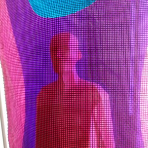 Puede incluir: Una tela de malla semitransparente con un dise&ntilde;o abstracto vibrante que presenta capas superpuestas de rosa brillante, morado intenso y azul cian. El material tiene una textura de rejilla distintiva que crea un efecto visual de capas.