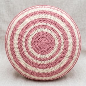 Peut inclure: Un coussin rond en crochet avec un motif rayé concentrique rose poudré et crème. Le coussin fait main présente des bandes de couleurs alternées, créant un effet de spirale. Un accessoire de décoration pour la maison.