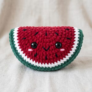 Può includere: Un peluche all'uncinetto a forma di mezzaluna che rappresenta una fetta di anguria. Il centro è rosso scuro con semi neri ricamati, due grandi occhi in plastica nera, un piccolo sorriso nero e due guance rosa cucite.
