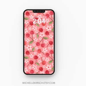 Könnte beinhalten: Eine rosa Handy-Tapete mit einem Muster aus roten Kirschen und weißen Blüten. Die Uhrzeit auf dem Handy-Bildschirm ist 2:04.