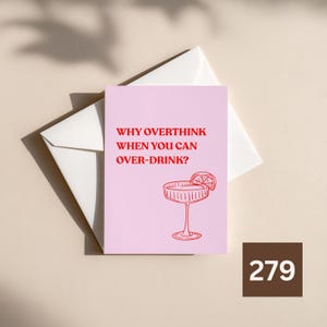 May include: A light pink greeting card with red text that reads WHY OVERTHINK WHEN YOU CAN OVER-DRINK? and a red line drawing of a cocktail glass with a citrus slice garnish, positioned on top of a plain white envelope.