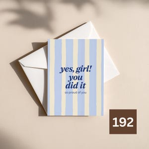 Peut inclure: Une carte de vœux rectangulaire avec un motif à rayures verticales bleu clair et crème. La carte présente un texte bleu foncé qui indique, yes, girl! you did it, suivi du texte plus petit, so proud of you. Une enveloppe blanche est placée derrière.