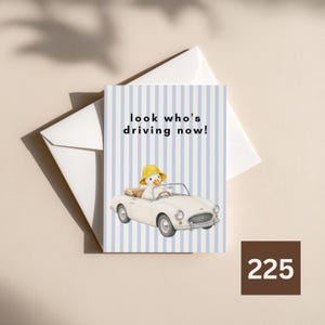Peut inclure: Une carte de vœux illustrée d'une voiture décapotable blanche conduite par un canard portant un chapeau jaune. Le fond présente des rayures verticales bleu clair. Le texte "look who's driving now!" est imprimé en noir au-dessus du canard.