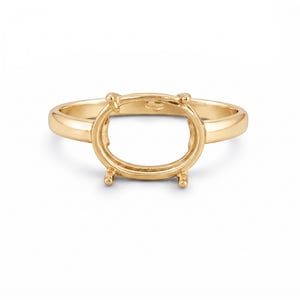 Peut inclure: Une bague en or avec un sertissage ovale conçu pour accueillir une pierre précieuse. La bague a un anneau lisse et poli et quatre griffes pour fixer la pierre. La bague est présentée sur fond blanc.