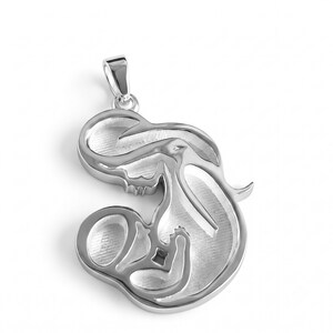May include: A silver-toned pendant featuring a stylised, abstract outline of a figure cradling a smaller form. The metal surface has a brushed, textured finish within the recessed areas, contrasted by smooth, polished edges and a top bail loop.