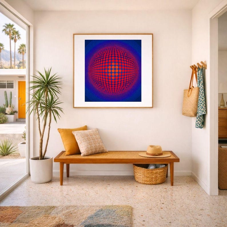 May include: An interior scene with a framed abstract artwork with a red and blue spherical design. A wooden bench with cushions and a woven basket is below the artwork. A potted plant and a rug complete the decor.