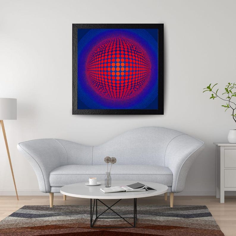 May include: A framed abstract art print with a striking red and blue spherical pattern. The black-framed artwork hangs above a grey sofa and a round coffee table, contributing to a contemporary living room setting.