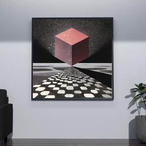 Pode incluir: Impress&atilde;o de arte emoldurada com um design geom&eacute;trico. Um cubo vermelho flutua acima de um caminho quadriculado, contra um c&eacute;u estrelado. A obra de arte tem uma qualidade surreal e on&iacute;rica, com uma moldura preta.