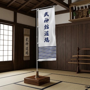 Könnte beinhalten: Ein weißes Banner mit blauem japanischem Text und horizontalen blauen Streifen am unteren Rand, das auf einem Holzständer ausgestellt ist. Auf dem Banner steht "Bushinkan Dojo". Die Szene spielt in einem traditionellen japanischen Raum.