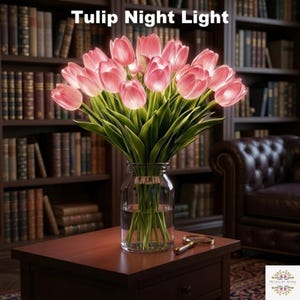 May include: A bouquet of illuminated pink tulip flowers in a clear glass vase. The tulips feature soft glowing petals and green stems. The text Tulip Night Light is displayed at the top, and a small logo is visible in the bottom right corner.