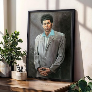 May include: A framed portrait of a man in a light gray suit with a light blue shirt. The portrait is displayed on a wooden surface next to a potted plant and a pencil holder. The portrait has a black frame.