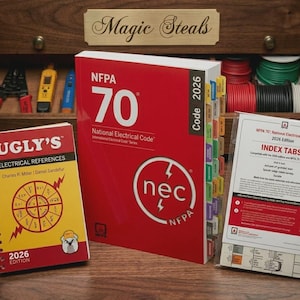 May include: A display of electrical reference materials, including a large red "NFPA 70" book, a spiral-bound "Ugly's" reference, and index tabs. The books are on a wooden surface, with tools and spools of wire visible in the background.