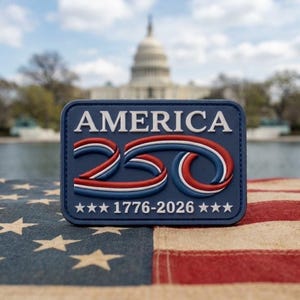 May include: A rectangular navy blue patch featuring the white text AMERICA, a stylized red, white, and blue number 250, and the white text 1776-2026 flanked by three white stars on each side, all rendered in a raised, three-dimensional design.