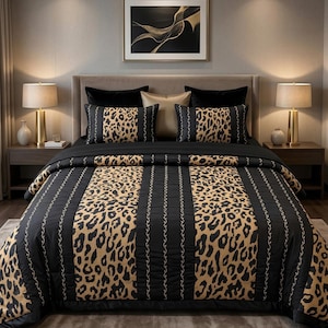 Op de afbeelding: Een luxe beddengoedset met een zwart- en bruin gevlekt dekbedovertrek en bijpassende kussenslopen. Het beddengoed is geaccentueerd met zwarte en gouden decoratieve elementen. De slaapkamer bevat ook een ingelijst abstract kunstwerk en twee nachtlampjes.