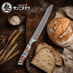 May include: A serrated bread knife with a patterned blade and a decorative handle rests on a wooden cutting board. The handle features a brown, white, and gray design. The image also includes a loaf of bread and slices.