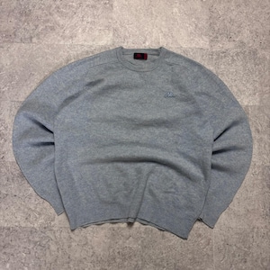 Può includere: Un maglione a maniche lunghe color grigio chiaro con girocollo, caratterizzato da colletto, polsini e orlo a coste. Il capo presenta un piccolo logo Kappa ricamato sul petto a sinistra e un'etichetta nera del marchio all'interno.