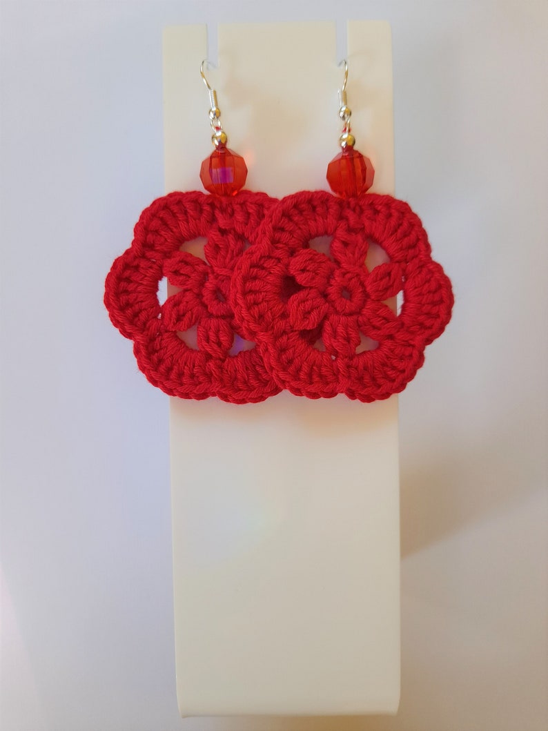 May include: Red crocheted earrings with a red crystal bead on each earring.