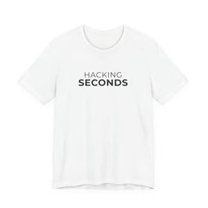 May include: White t-shirt with the text "HACKING SECONDS" in black, centered on the chest. The shirt has a crew neck and short sleeves. The fabric appears to be a soft, lightweight material.
