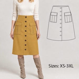 May include: A mustard yellow knee-length skirt featuring a front button closure, two large patch pockets with vertical pleats, and a high waist. A black and white line drawing of the skirt is shown alongside the text: Sizes: XS-3XL.