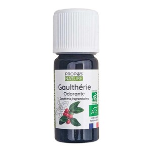 May include: A small, dark glass bottle with a white cap. The label reads "PROPOS' NATURE Gaulthérie Odorante" with a botanical illustration of red berries and green leaves. The bottle contains a dark liquid.