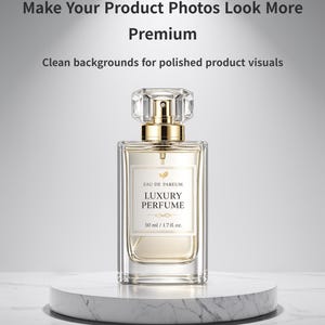May include: A rectangular perfume bottle with a clear glass body and a gold-colored top. The label reads "EAU DE PAREUM LUXURY PERFUME 50 ml / 1.7 fl. oz." The bottle sits on a white marble pedestal. The text above reads "Make Your Product Photos Look More Premium."
